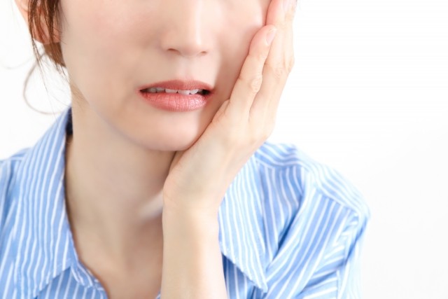 抜歯後に痛みを感じる女性