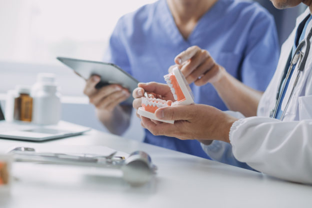 Dentists are discussing dental problems at report x-ray image on