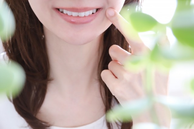 歯を指さす女性