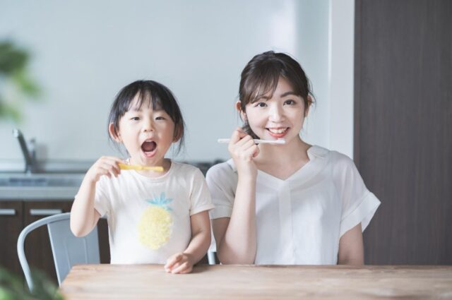 母親と歯磨きをする女の子